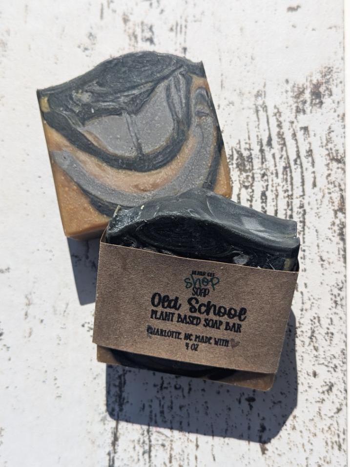 A neatly stacked display of Old School soaps, showcasing their handcrafted variations and eco-friendly packaging.