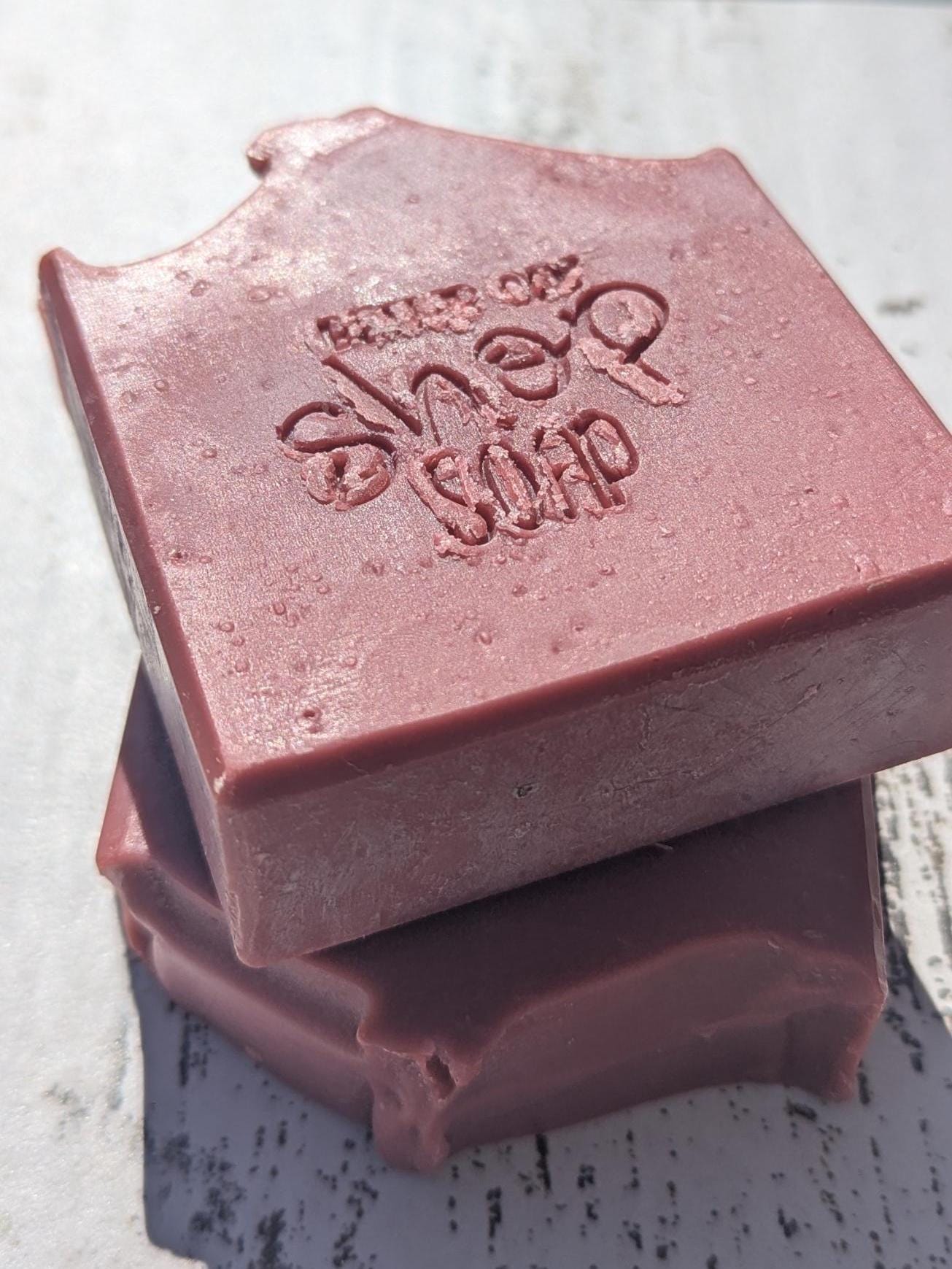 A vibrant hot pink Sophomoric handmade soap bar, featuring beveled edges for a sleek, polished look.