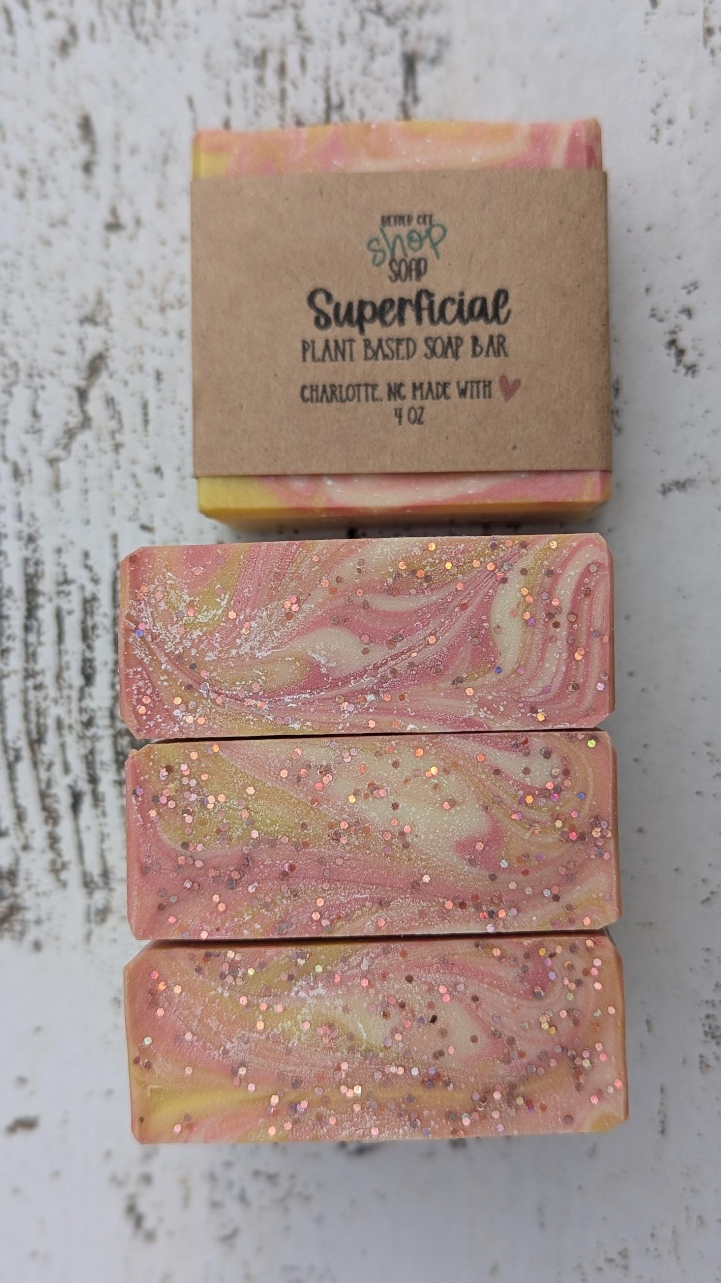 Superficial soap bars standing up to display the glitter on the tops.
The colorful swirl design complements the fruity and floral scent profile.