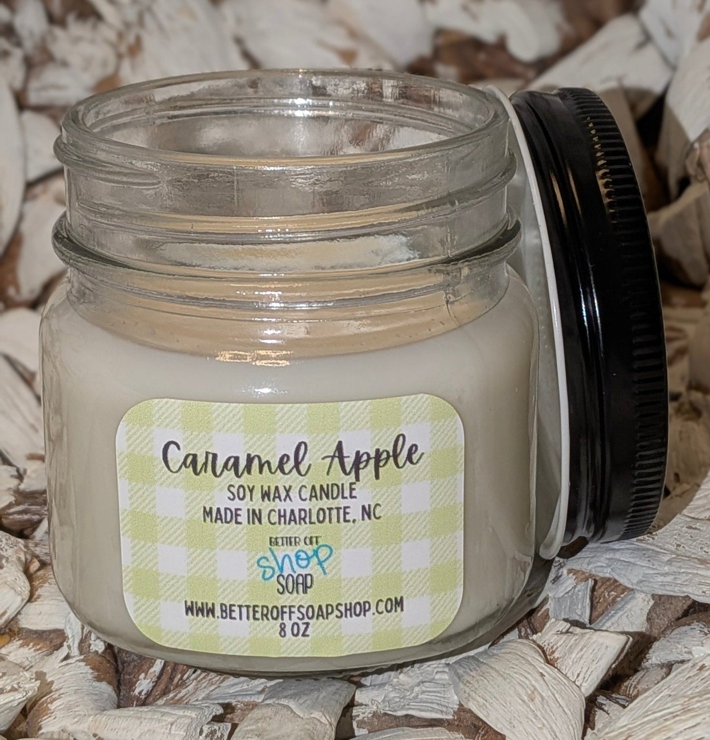 Candle jar labeled 'Caramel Apple' on a wooden surface