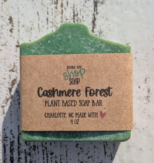 Green bar of soap with a cardboard label on a textured surface