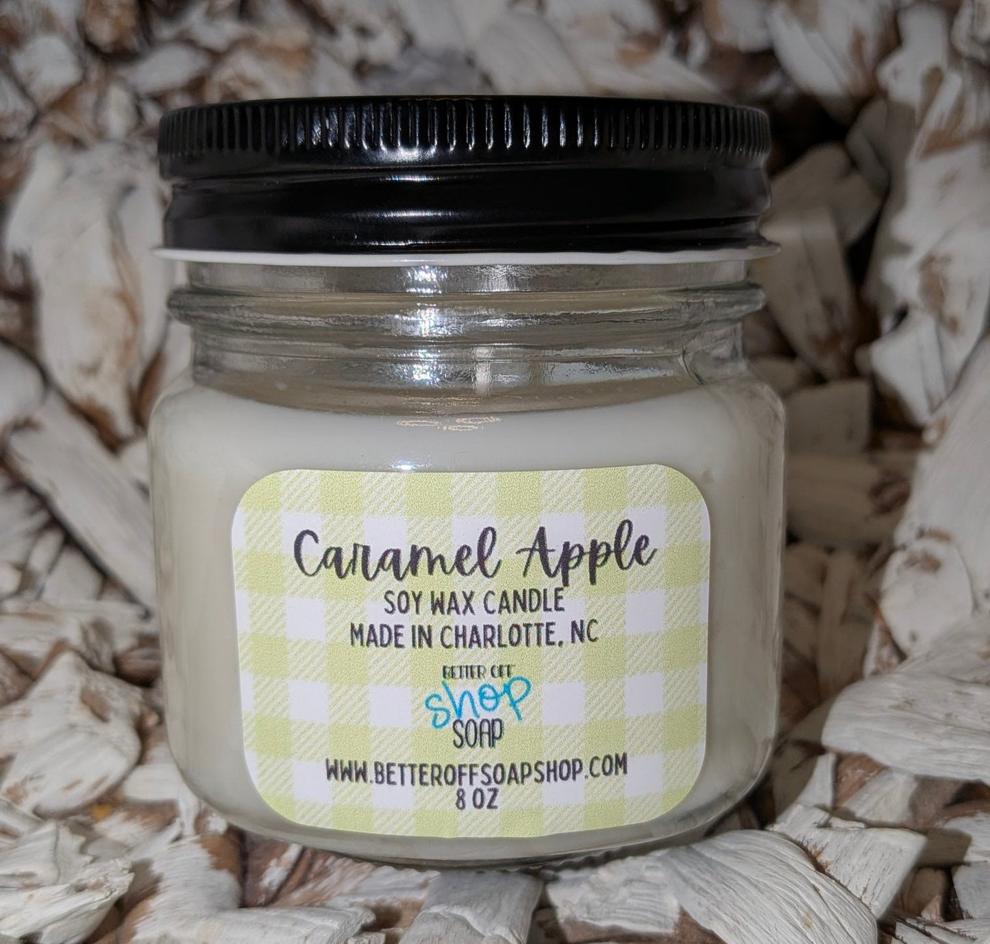 Candle jar labeled 'Caramel Apple' on a wooden background