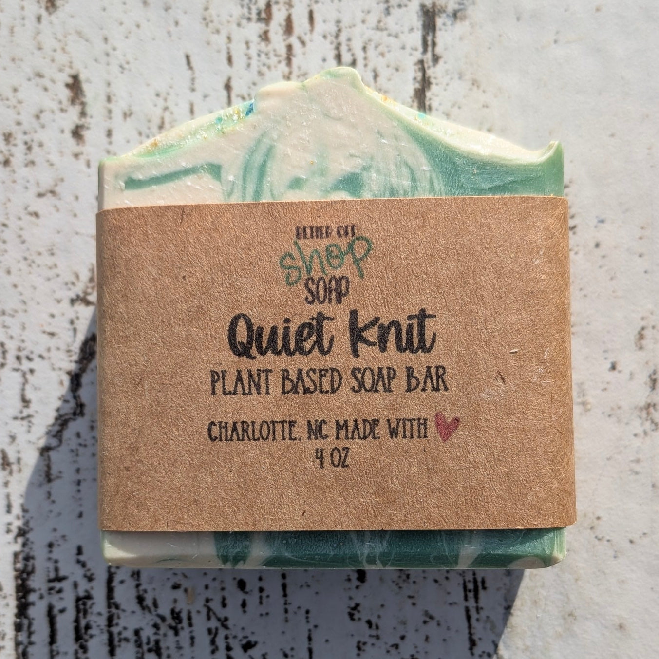 Bar of soap with a cardboard label on a textured surface