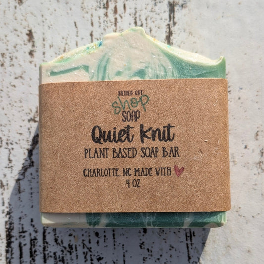 Bar of soap with a cardboard label on a textured surface